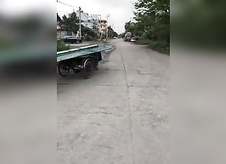 Un homme prend de gros risques pour ramener des tôles sur son tricycle motorisé (Viêt Nam)