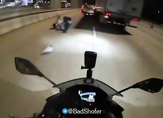 A motorcyclist is hit and nearly run over by a truck