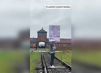 Il se tient à l'extérieur d'Auschwitz avec une pancarte pro-palestine