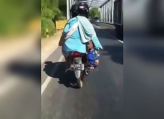 Les parents de l’année en moto avec leur petit enfant