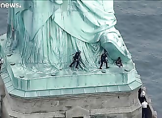 Pour dénoncer la politique de Trump, une femme gravit la statue de la Liberté