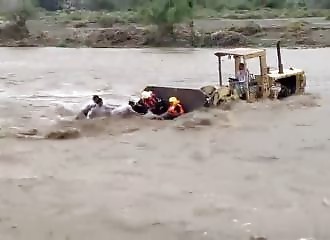 They use a backhoe to rescue people trapped in a river