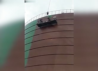 Suspendus à plusieurs mètres de hauteur, deux peintres se battent dans une nacelle