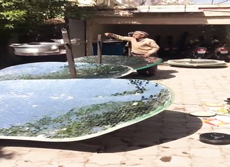 Un homme prépare le repas de midi avec des cuiseurs solaires paraboliques (Pakistan)
