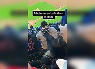 A woman harasses a man in front of her in the stands, watch to the end