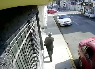 A bakery explodes while a pedestrian is standing in front of it