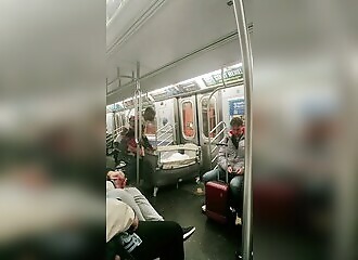 A man settles down to sleep in a cradle on the New York subway