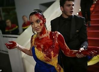 Une manifestante portant les couleurs de l'Ukraine se couvre de faux sang sur le tapis rouge de Cannes